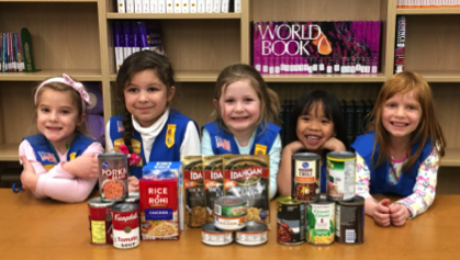 A group of Girl Scouts conducting a food drive.