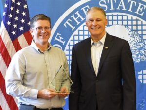 Employer Michael LaGrange holding the Governor’s award with Governor Inslee.