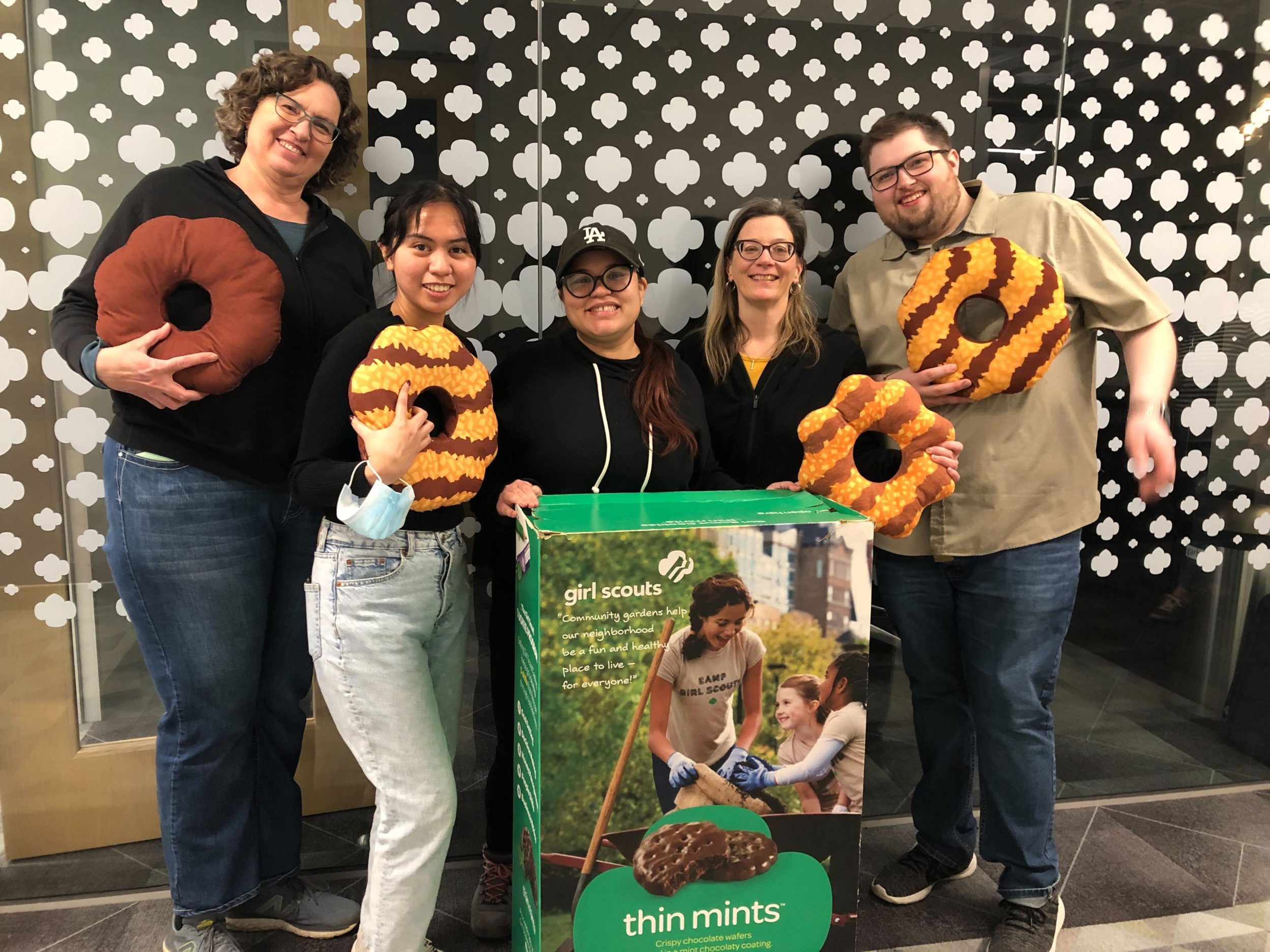 NAWA staff in front of the new office holding Girl Scout cookie pillow